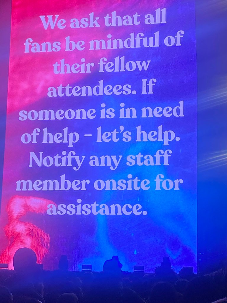 A sign that says, "We ask that all fan be mindful of their fellow attendees. If someone is in need of help — let's help. Notify any staff member onsite for assistance."